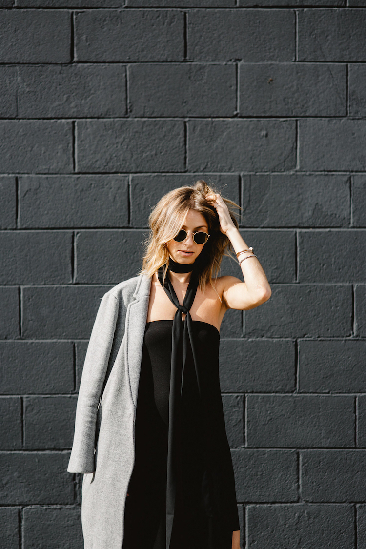 strapless black dress, neck scarf, coat on one shoulder