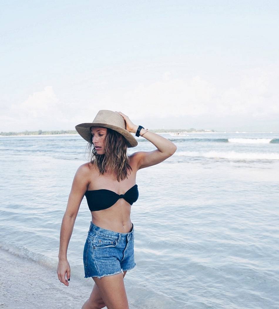 straw hat bikini top denim shorts on bali beach 