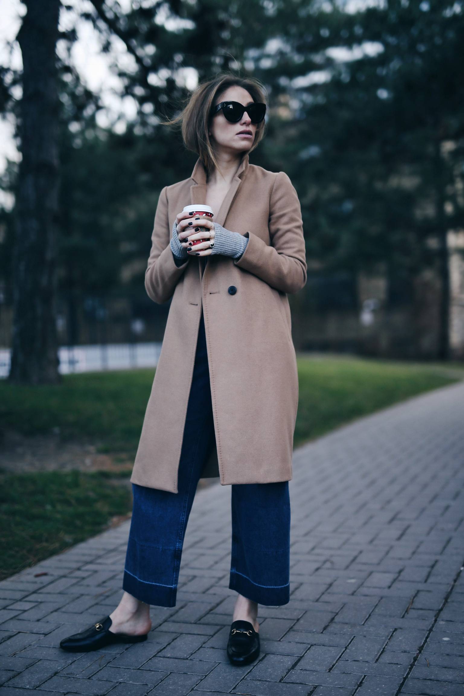 Style and beauty blogger Jill Lansky of The August Diaries in Aritzia camel coat + Gucci slides, Rachel Comey jeans, Celine sunglasses
