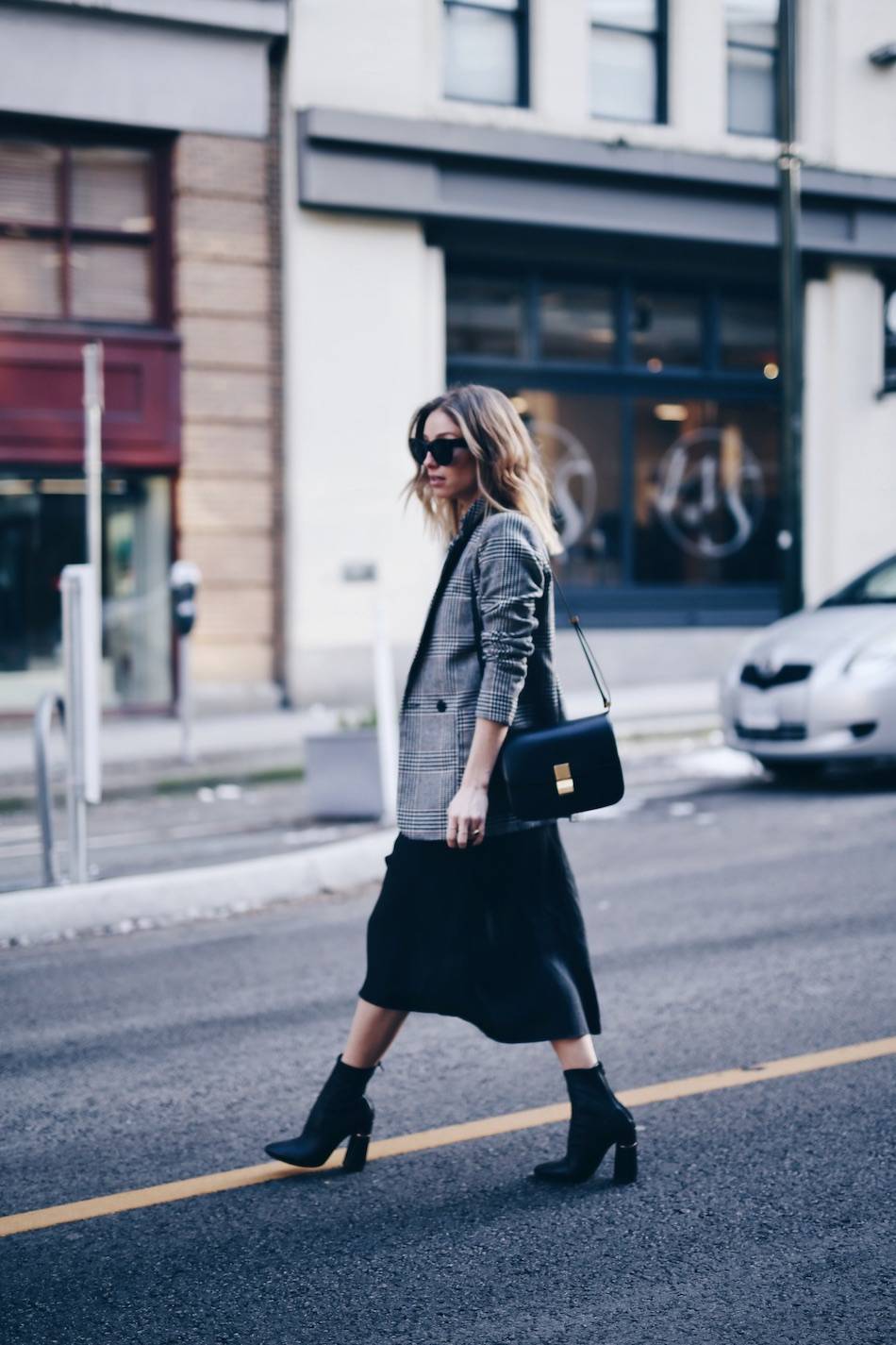 Style and beauty blogger Jill Lansky of The August Diaries in perfect black slip dress, H&M plaid boyfriend blazer, Celine bag