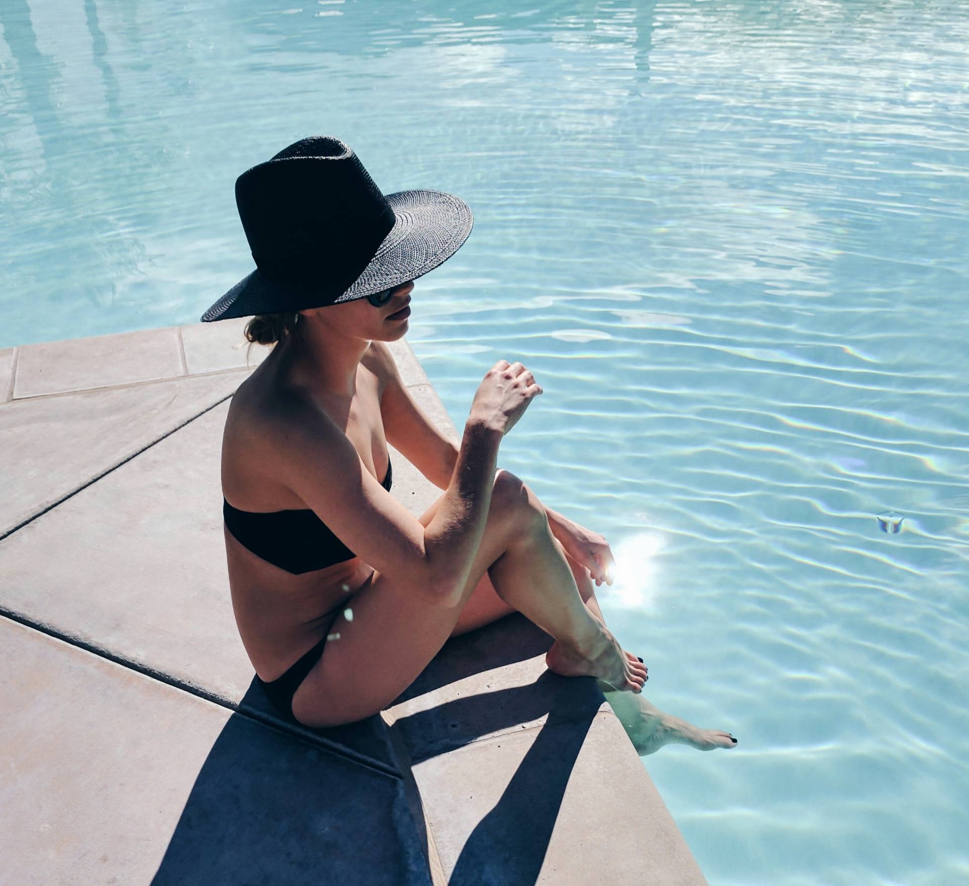 summer hat styles - black straw hat by the pool