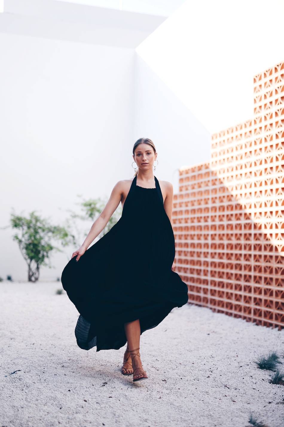 Style and beauty blogger Jill Lansky of The August Diaries on what to wear to dinner on vacation in Aritzia black maxi dress, Madewell leather gladiator sandals and gold statement earrings