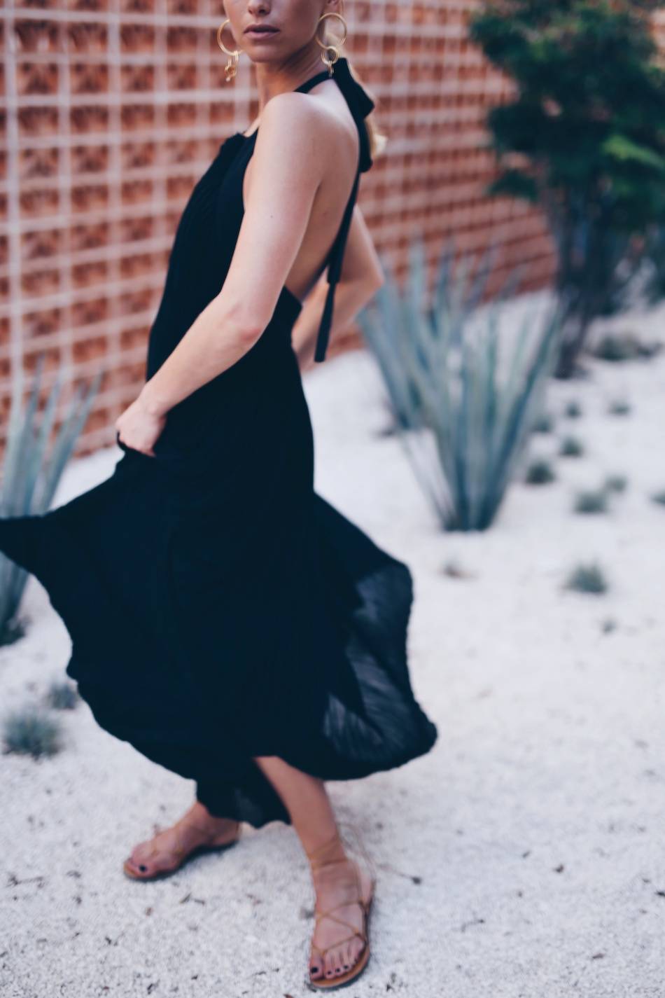 Style and beauty blogger Jill Lansky of The August Diaries on what to wear to dinner on vacation in Aritzia black maxi dress, gladiator sandals, statement earrings