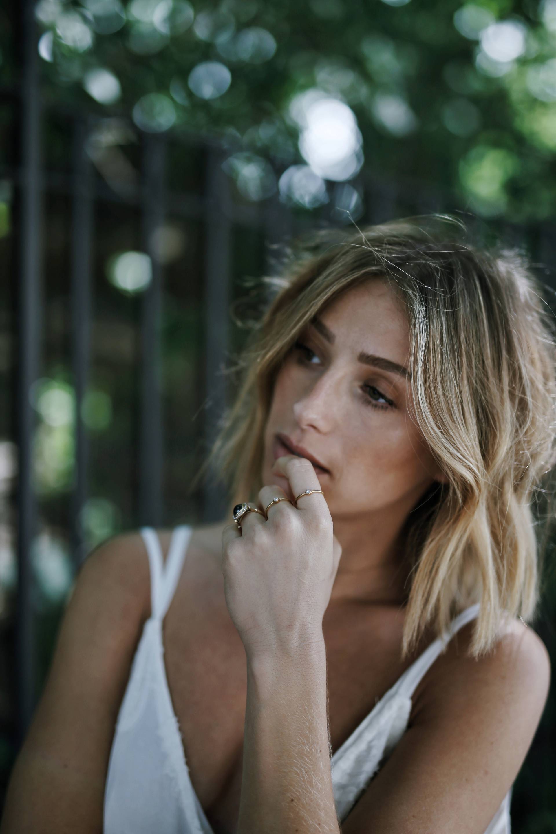 Style and beauty blogger Jill Lansky of The August Diaries in a white dress and gold jewelry, black diamond engagement ring