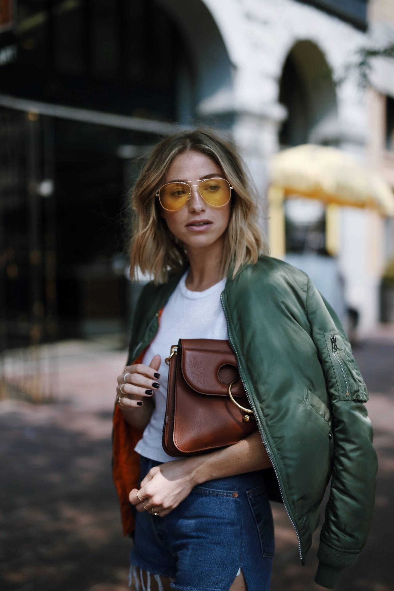 Style and beauty blogger Jill Lansky of The August Diaries on how to mix comfort and style in Alpha Industries bomber jacket, yellow sunglasses, long bob, beachy waves